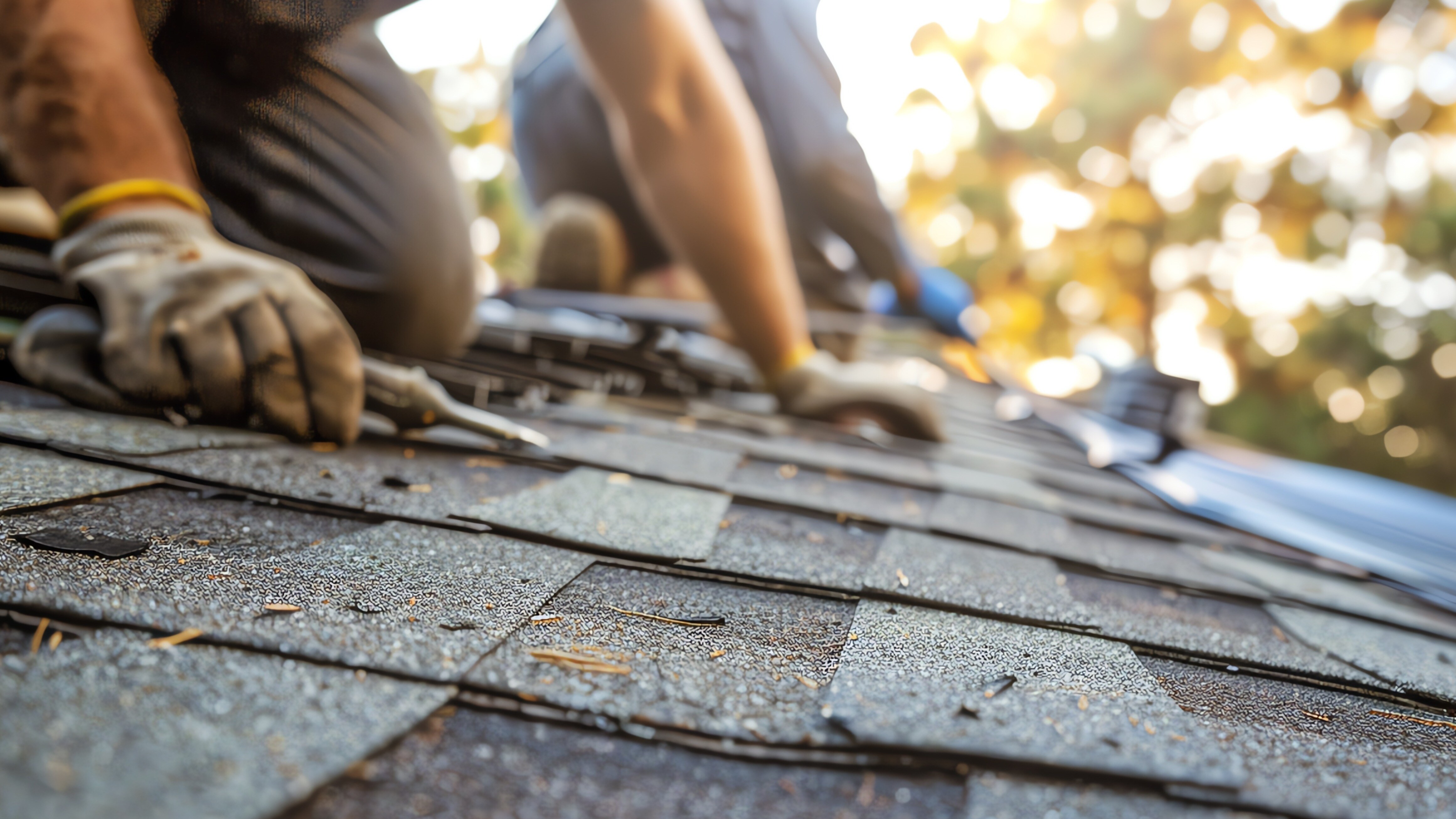 Contractor on roof, repairing it with new shingles